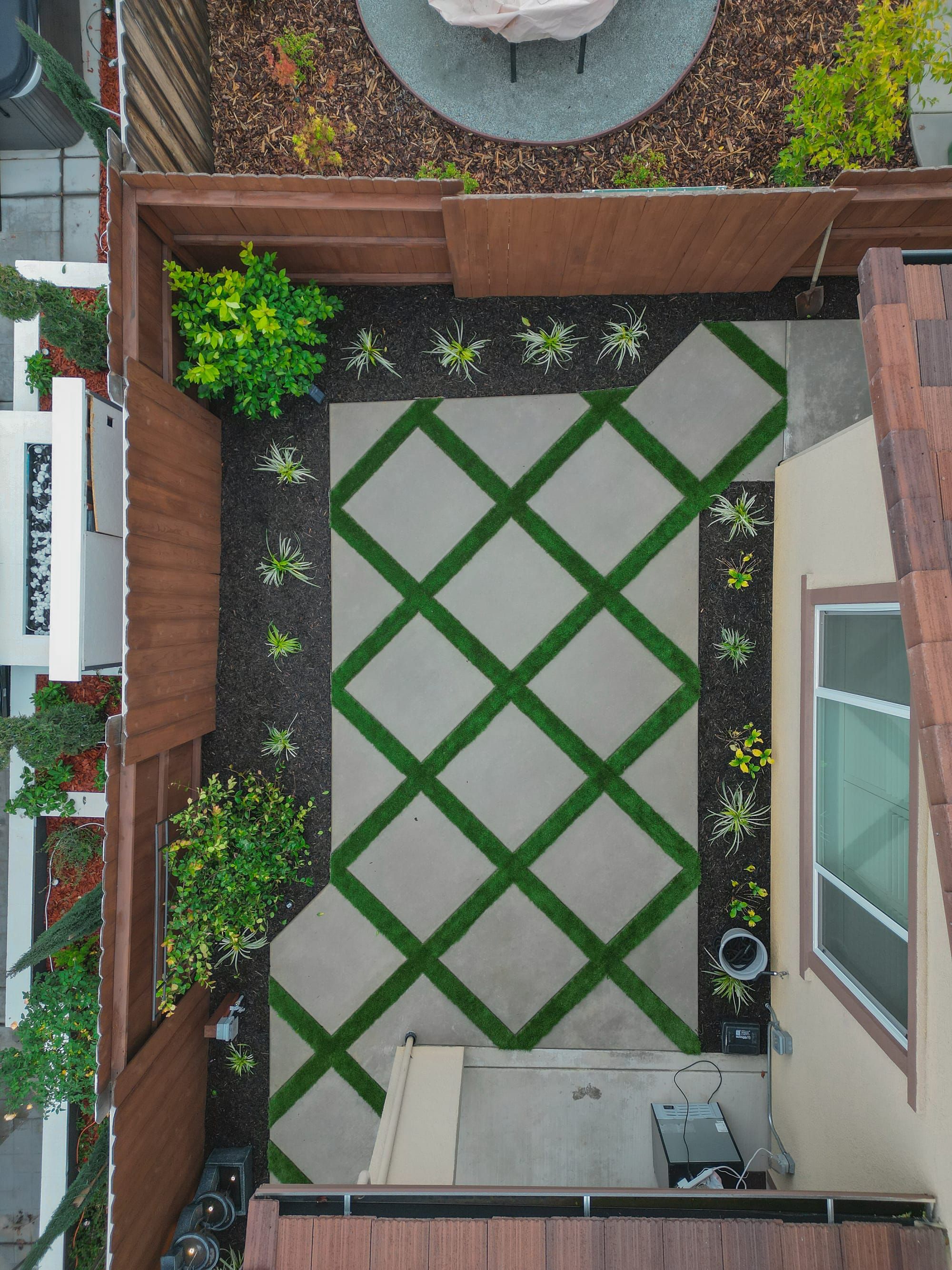 Aerial view of diamond-pattern patio with turf inlay and plantings in Sacramento