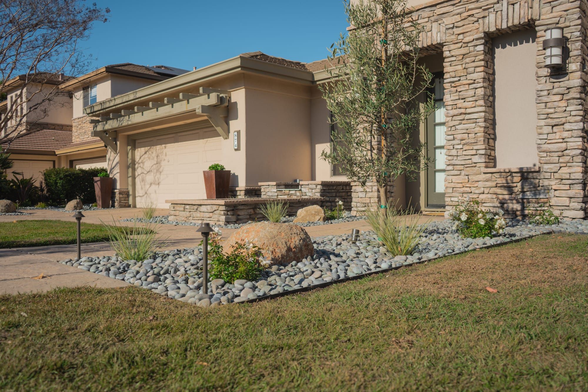 Front yard landscape design with stone veneer and path lighting in Sacramento