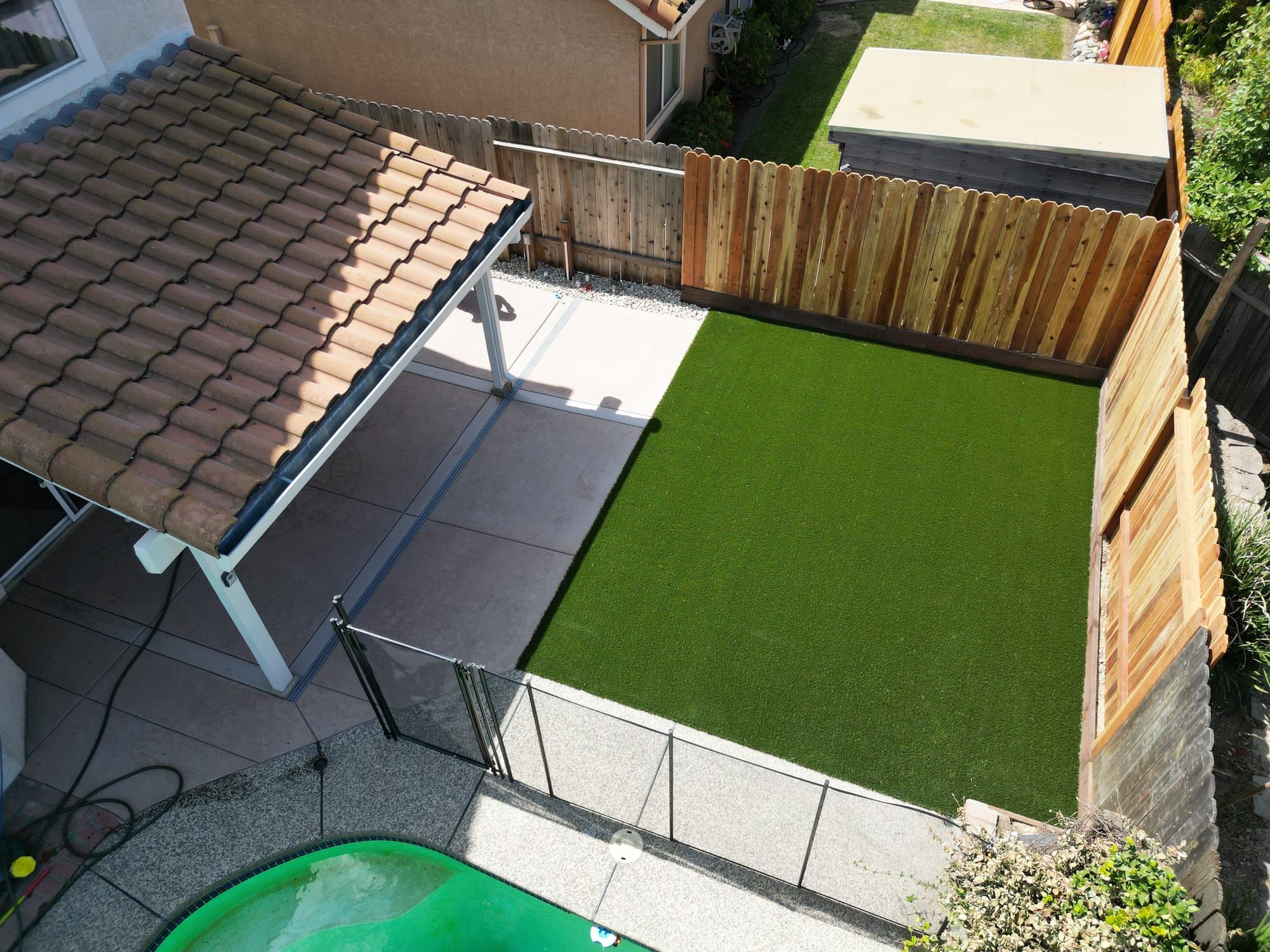 Aerial view of backyard with artificial turf, patio, and pergola in Sacramento