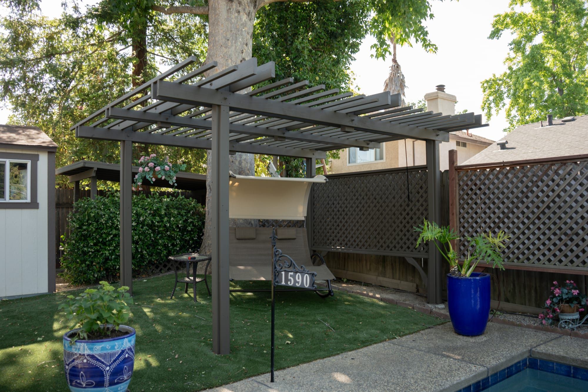 Custom pergola with artificial turf and pool area in Sacramento backyard
